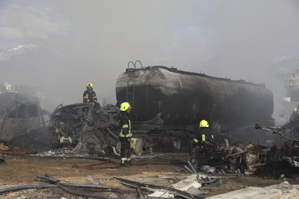 Firefighters work to extinguish a burning fuel tanker in Kabul, Afghanistan, Sunday, May 2, 2021. A fire roared through several fuel tankers on the northern edge of the Afghan capital late Saturday, injuring at least 10 people and plunging much of the city into darkness, officials said. (AP Photo/Rahmat Gul)