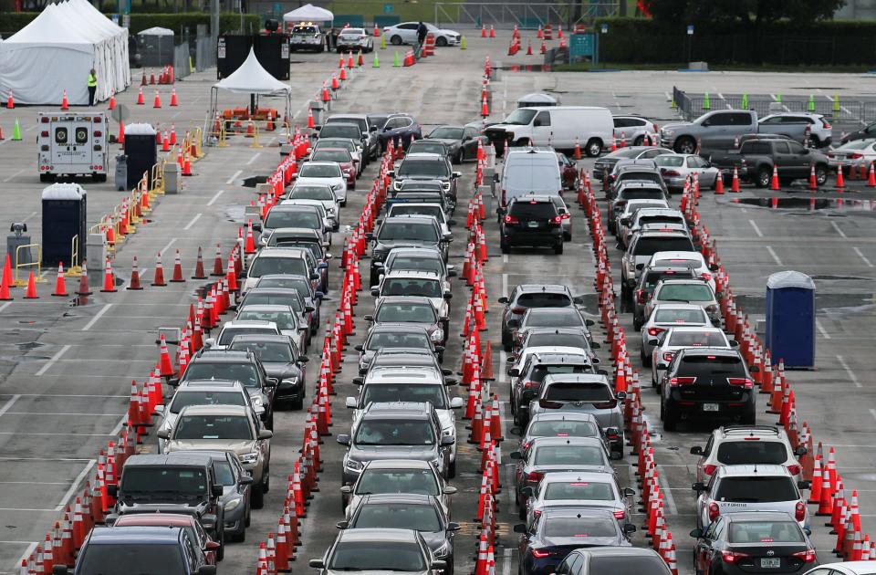 Drivers wait to be tested for COVID-19 at the Hard Rock Stadium parking lot July 6 in Miami Gardens, Fla. The state is experiencing a spike in  coronavirus cases and plans to close some businesses to combat the rise.