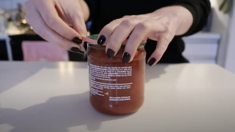 woman using rubber band to open jar