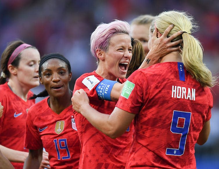 Women footballers in red kit celebrating