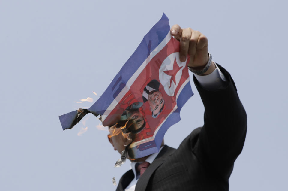 FILE- In this April 27, 2018, file photo, a man burns a North Korean flag with photos of North Korean leader Kim Jong Un, the late leaders Kim Jong Il and Kim Il Sung during a rally outside the Imjingak Pavilion in Paju, South Korea. Kim and South Korean President Moon Jae-in announced in the North Korean capital of Pyongyang this week that Kim has accepted Moon’s request to visit Seoul soon, maybe within the year.(AP Photo/Lee Jin-man, File)