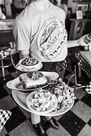 Robbie Caponetto Ajax Diner stacks its plates of food high.