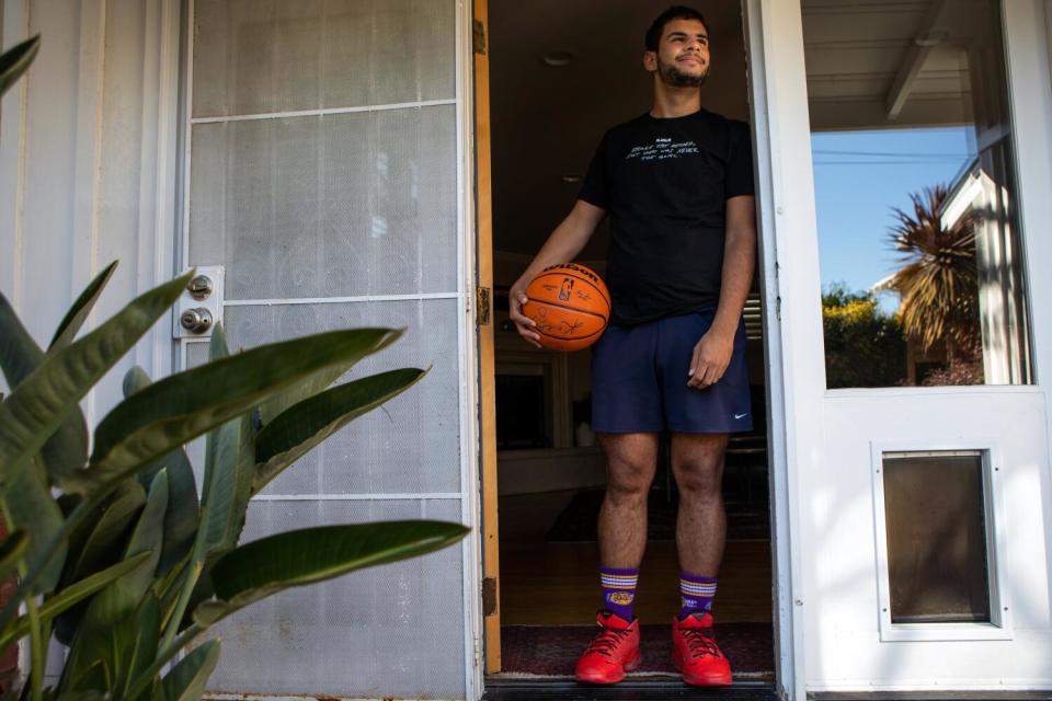 Portrait of Kade Weston in the doorframe of his home before basketball practice.