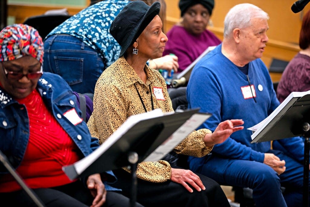 Genea Williams flips a page in her music while singing during a rehearsal for the Amazing Grace Chorus on Dec. 2 at Milwaukee Marshall High School in Milwaukee.