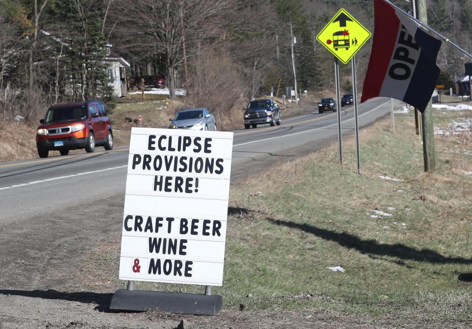 Traffic heading towards Lake Placid pass a sign for Eclipse provisions on Route 73 in Keene, New York April 7, 2024.