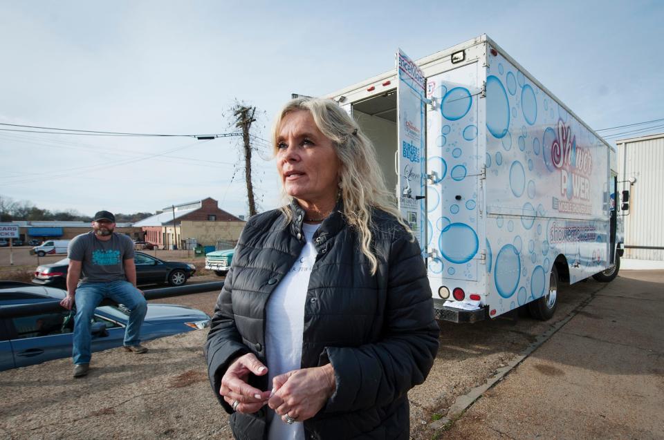 Teresa Renkenberger of Flowood, Miss., describes the inspiration for her Shower Power Mobile Shower Unit for the homeless. Kevin Poe, of Florence, background, converted the food truck to a mobile shower unit. The two were in Jackson on Dec. 5, 2019, where she makes the mobile shower available weekly.