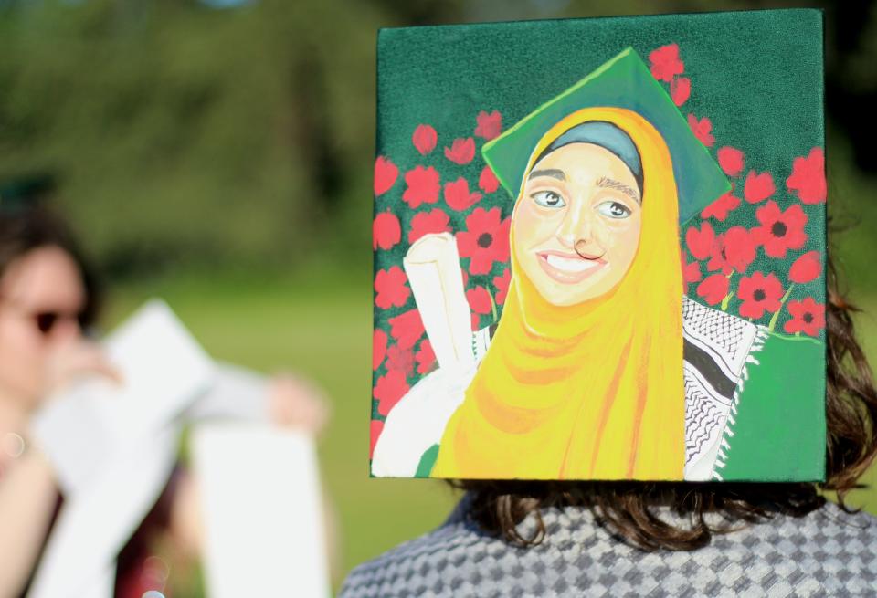 University of Oregon graduating senior Phia Dornberg honors Tala, a Palestinian university student who has been displaced by the violence in Gaza, with a painting on her cap.