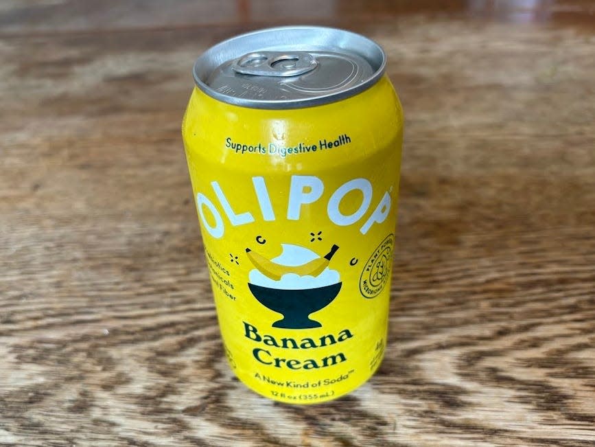 A can of banana-cream Olipop on a wooden table.