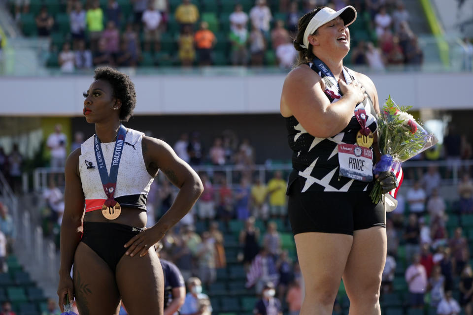 Gwendolyn Berry, left, looks away as DeAnna Price stands for the national anthem after the finals of the women's hammer throw at the U.S. Olympic Track and Field Trials Saturday, June 26, 2021, in Eugene, Ore. Price won and Berry finished third. (AP Photo/Charlie Riedel)