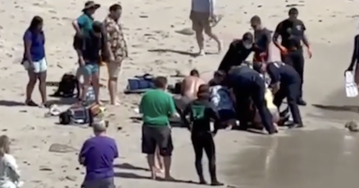 Beachgoers aid a surfer who had been attacked by a shark at Pacific Grove beach in California   (KSBW8)