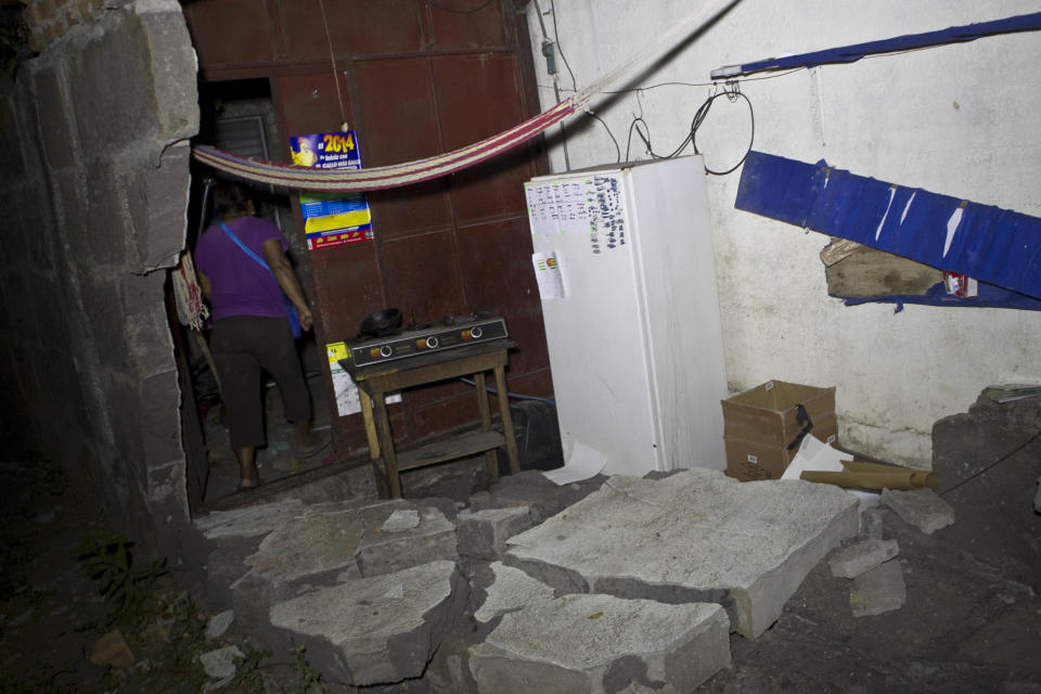 A woman walks inside a home that was damaged by an earthquake in Nagarote, Nicaragua, Thursday, April 10, 2014. A 6.1-magnitude earthquake damaged dozens of houses in western Nicaragua on Thursday, and authorities said some people were injured by falling ceilings, beams and walls. (AP Photo/Esteban Felix)