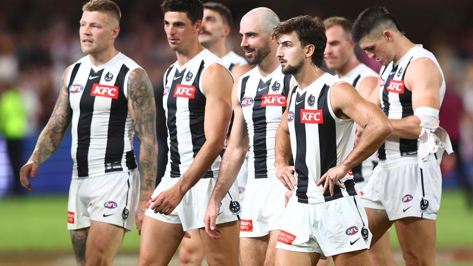 Collingwood players walk off the ground.