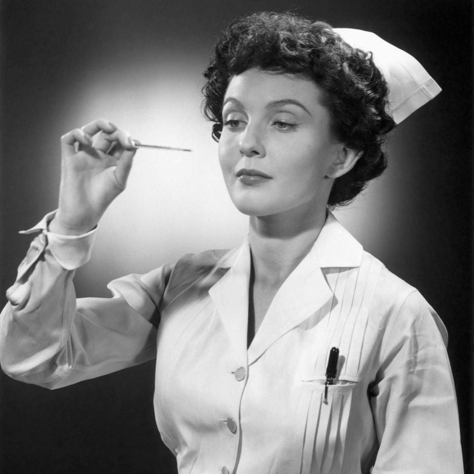 Nurse reading thermometer - vintage - George Marx/Getty Images