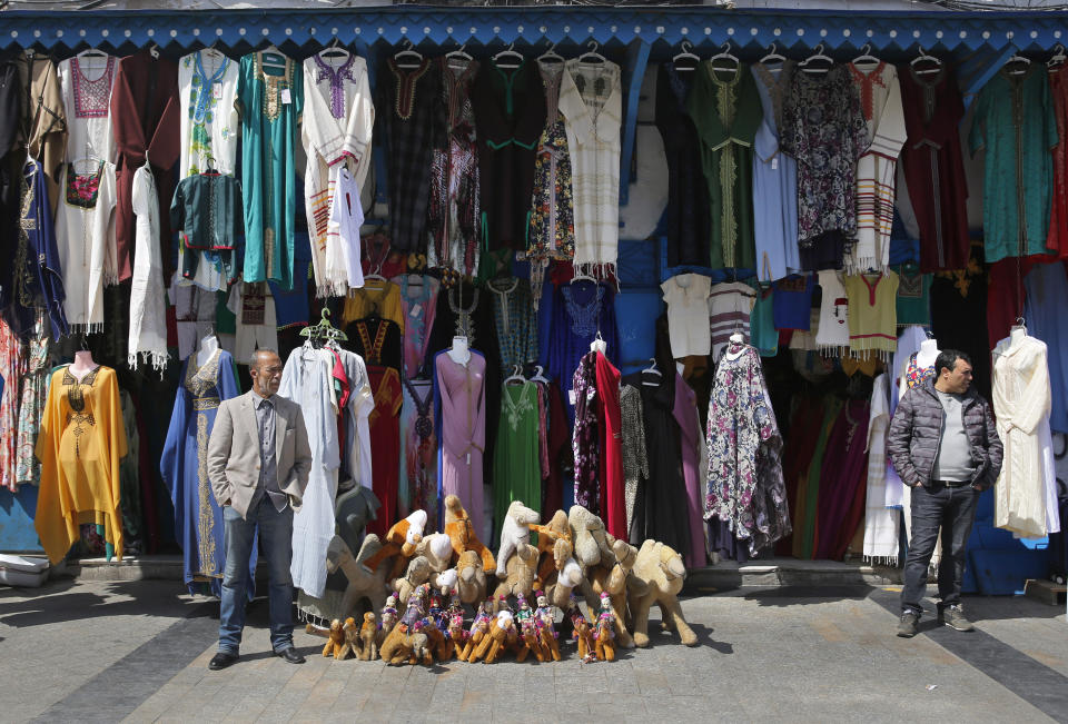 Tunisian vendors stand outside their shops at a popular market, in the Old City of Tunis, Tunisia, Thursday, March 28, 2019. Tunisia is cleaning up its boulevards and securing its borders for an Arab League summit that this country hopes raises its regional profile and economic prospects. Government ministers from the 22 Arab League states are holding preparatory meetings in Tunis all week for Sunday's summit. (AP Photo/Hussein Malla)