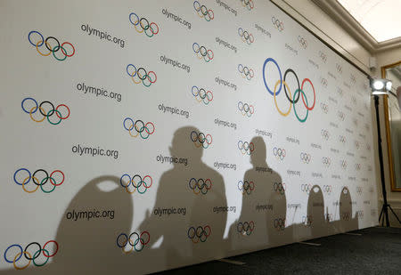 International Olympic Committee (IOC) President Thomas Bach and Communication director Mark Adams cast a shadow during a news conference after an Executive Board meeting in Lausanne, Switzerland, December 8, 2016. REUTERS/Denis Balibouse