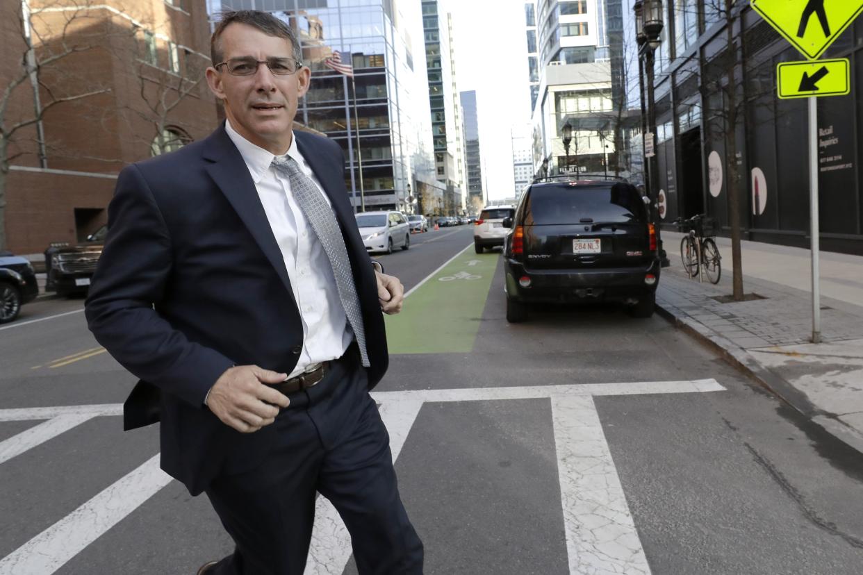 Michael Center, former men's tennis coach at the University of Texas at Austin, runs from federal court in Boston, Monday, Feb. 24, 2020, after being sentenced in a nationwide college admissions bribery scandal. (AP Photo/Steven Senne)