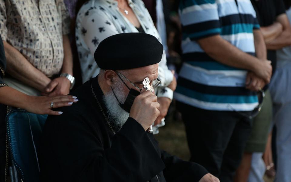 People mourn outside the St. George Coptic Orthodox Church which was destroyed by an early-morning fire Monday in Surrey, British Columbia. - Mert Alper Davis/Anadoulou