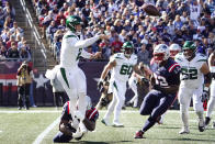 New York Jets quarterback Zach Wilson (2) passes the ball as New England Patriots defensive tackle Christian Barmore (90) grabs his ankles during the first half of an NFL football game, Sunday, Oct. 24, 2021, in Foxborough, Mass. At right is New England Patriots free safety Devin McCourty. (AP Photo/Mary Schwalm)