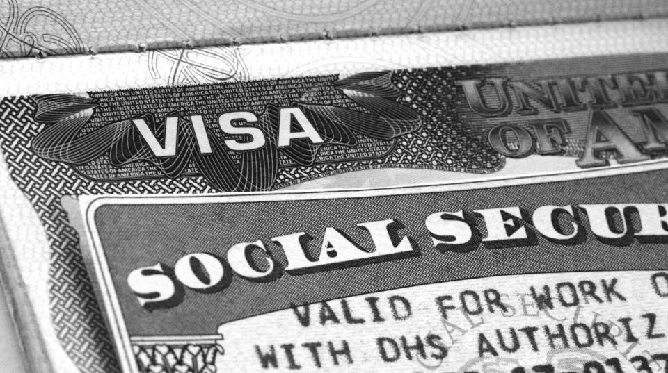 A Social Security card atop a work visa.