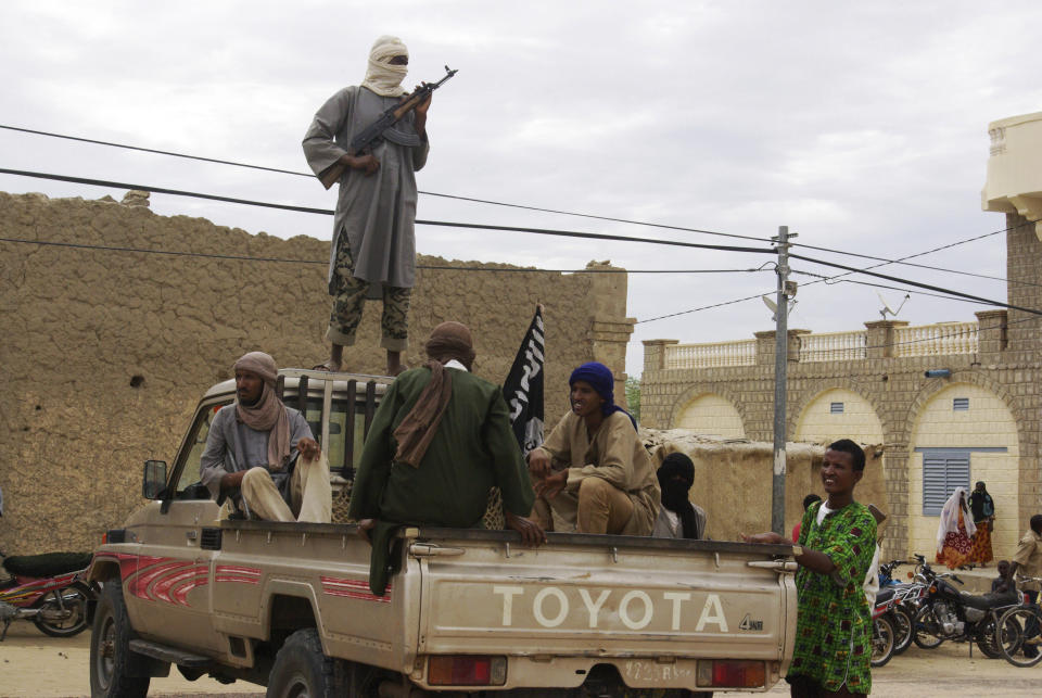 En esta imagen de archivo, combatientes del grupo islamista Ansar Dine hacen guarda en Tombuctú, Malí, el 31 de agosto de 2012, mientras se preparan para dar latigazos a un miembro de la policía islámica culpable de adulterio. (AP Foto/archivo)