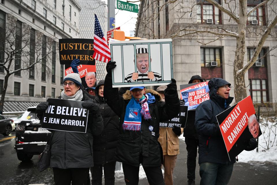 People hold signs outside the Manhattan federal court in New York for the second defamation trial against former president and 2024 candidate Donald Trump. Former magazine columnist E. Jean Carroll claims Trump sexually assaulted her in 1995.