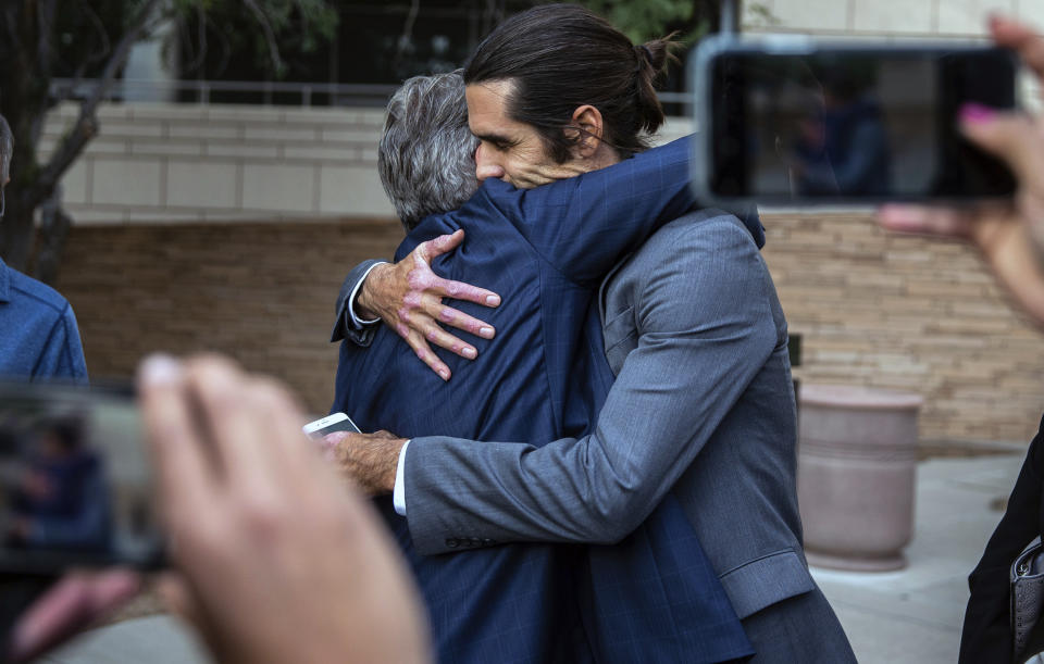 Attorney Greg Kuykendall and border aid volunteer Scott Warren embrace outside the Federal Courthouse, Wednesday, Nov. 20, 2019 in Tucson, Ariz. Warren was acquitted Wednesday on charges he illegally harbored two Central American immigrants at a camp in southern Arizona operated by a humanitarian group. (Josh Galemore/Arizona Daily Star via AP)