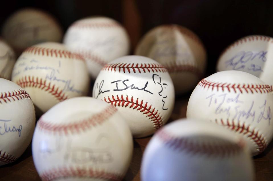 In this March 13, 2014 photo, a signed baseball with a self-portrait by rock musician Chris Isaak is shown in Dusty Baker's collection at his home in Granite Bay, Calif. Out of uniform for the first time since taking 2007 off between managerial jobs with the Cubs and Reds, Baker is not slowing down much from his pressure-packed days in the dugout. (AP Photo/Eric Risberg)