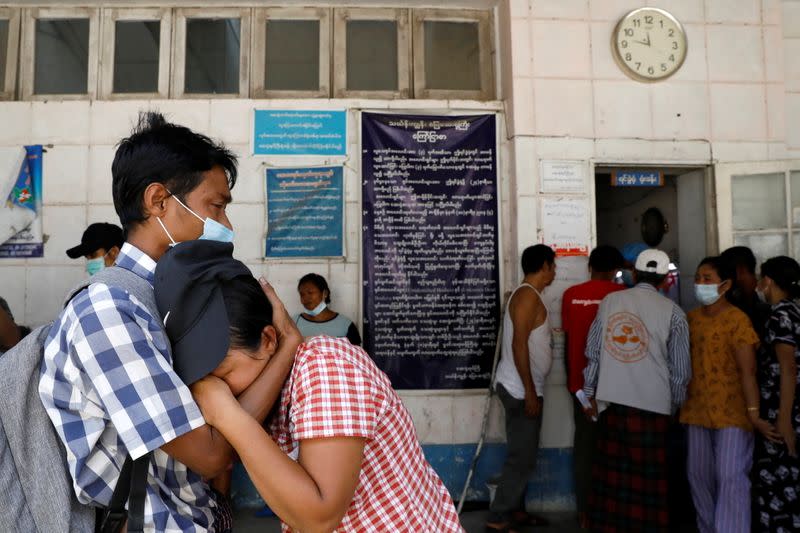 Relatives of anti-coup protester victims wait outside the morgue for the return of their bodies at Thingangyun Hospital in Yangon