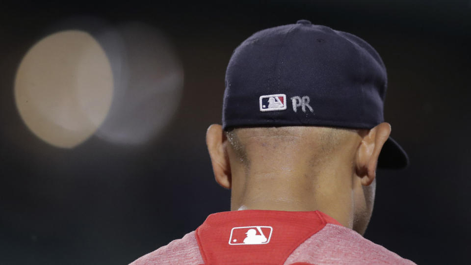 Boston Red Sox manager Alex Cora's cap is embossed with the letters "PR", for his Puerto Rico homeland, during a baseball game at Fenway Park in Boston, Wednesday, July 17, 2019. (AP Photo/Charles Krupa)