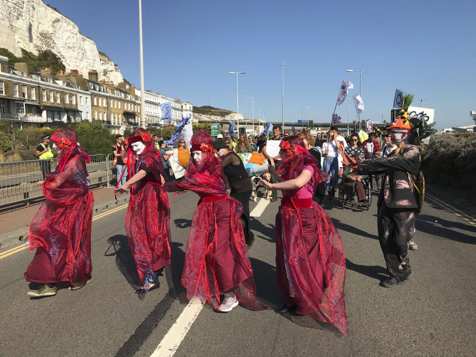 Extinction Rebellion protesters occupy one side of a dual carriageway at the port of Dover, England, Saturday Sept. 21, 2019. Traffic around the Port of Dover, England's major sea connection with France, has been disrupted as a result of a protest by environmental activists. Activists from Extinction Rebellion said their protest around the port is intended to "highlight the vulnerability of the U.K.'s food supply in the face of the ecological and climate emergency." (Michael Drummond/PA via AP)