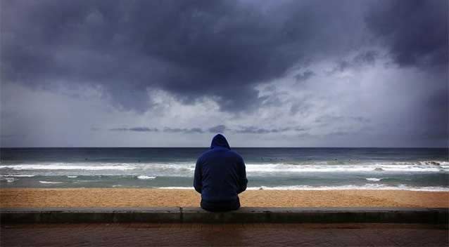 A surfer looks at waves as storm clouds move in at Sydney's Manly Beach. The Australian Weather Bureau said models suggest El Nino development remains possible during the coming months. Photo: REUTERS/David Gray