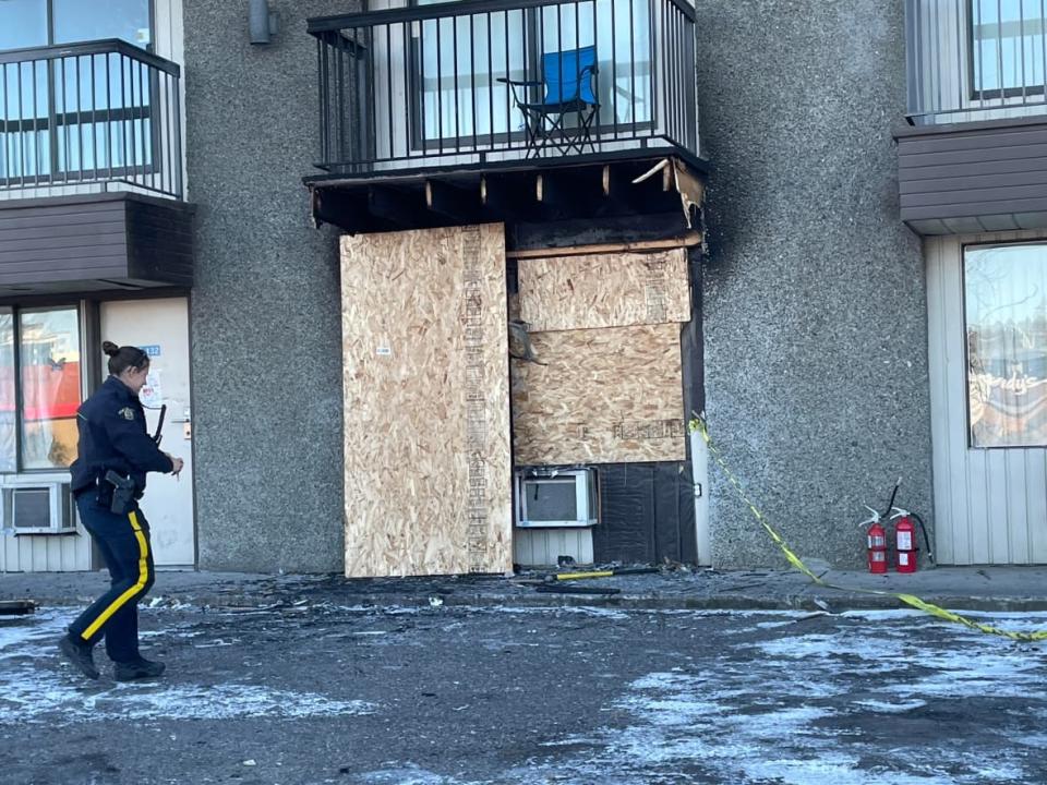 A Prince George RCMP officer outside a burned-out motel room at the North Star Inn, where one person was found dead, and two more were seriously injured following a Saturday night fire. (Betsy Trumpener/CBC - image credit)