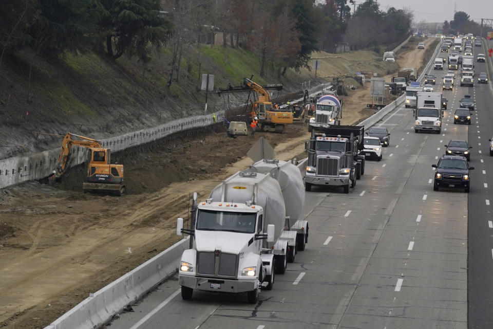 Trucks and other vehicles pass a construction zone on Highway 50 in Sacramento, Calif., Monday, Dec. 6, 2021. The California Air Resources Board, on Thursday, Dec. 9, 2021, is considering a new smog check program for heavy duty trucks. The new rules would require trucks weighing more than 14,000 pounds to be tested at least twice per year to make sure they meet the state's smog standards. (AP Photo/Rich Pedroncelli)