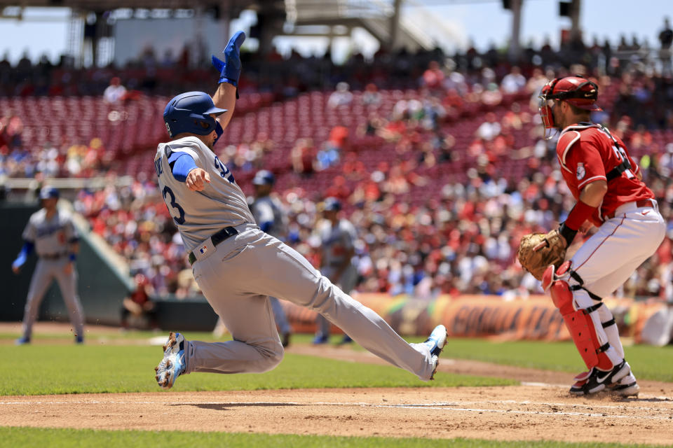 Los Angeles Dodgers' Max Muncy slides into home plate as he scores a run on a sacrifice fly by Cody Bellinger during the second inning a baseball game against the Cincinnati Reds in Cincinnati, Thursday, June 23, 2022. (AP Photo/Aaron Doster)