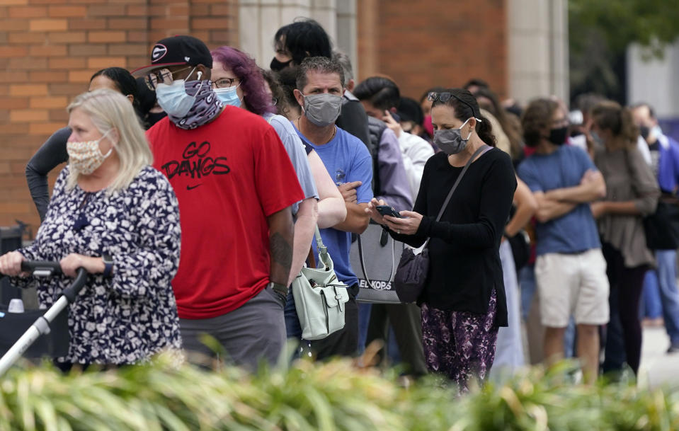 Voters line up and wit to cast a ballot at the American Airlines Center during early voting Thursday, Oct. 15, 2020, in Dallas. (AP Photo/LM Otero)