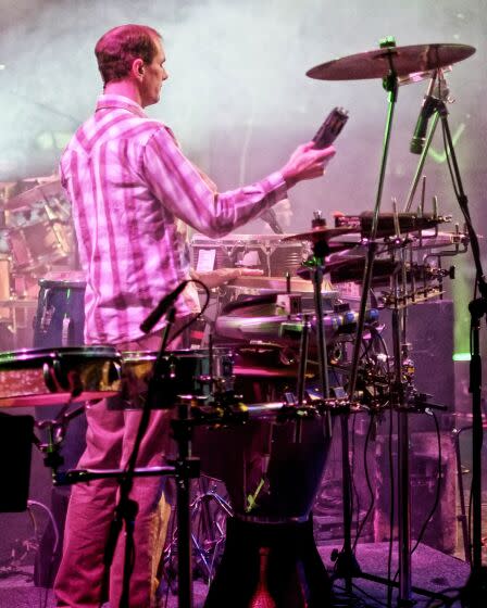 Percussionist Chuck Morris stands behind his drum set during a live concert.