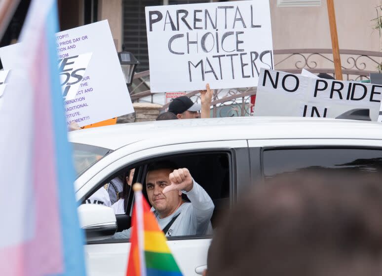 NORTH HOLLYWOOD, CA - JUNE 02: A passing motorist shows his feelings as he passes counterprotesters in front of Saticoy Elementary School on Friday, June 2, 2023. Some parents kept their children home from school to protest the planned Gay Pride and Rainbow Day assembly The parents said they have to right to teach or not teach their children about gay relationships and said that they are too small to be taught this material. They directed their ire at the Los Angeles Unified School District. (Myung J. Chun / Los Angeles Times)