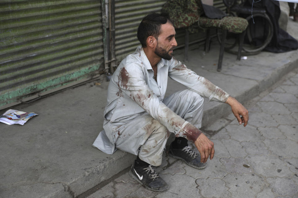 A blood-stained man rests after he helped people who were injured in a deadly bomb explosion in Kabul, Afghanistan, Tuesday, July 13, 2021. The bomb killed several people and wounded over 10 others, Kabul police officials said on Tuesday. It comes as the U.S. all but winds up its 'forever war' in Afghanistan and a day after the outgoing commander Gen. Scott Miller warned increasing violence reduced the chances of finding a peaceful end to decades of war. (AP Photo/Rahmat Gul)