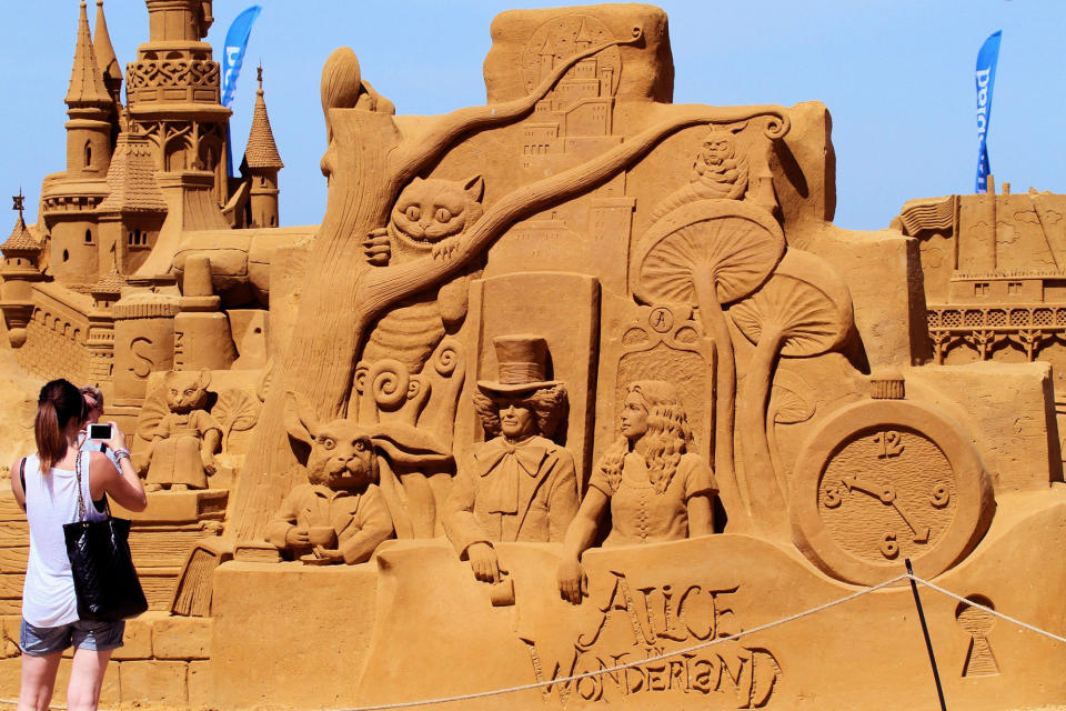 <p>An attendee takes a photo of a sculpture during the Sand Sculpture Festival “Disney Sand Magic” in Ostend, Belgium. (Photo courtesy of Disneyland Paris) </p>