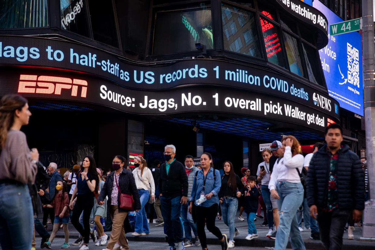 A crowded Times Square as a news ticker highlights the U.S. reaching 1 million COVID deaths. 