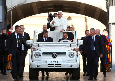 Pope Francis is escorted by Vatican security as he arrives to lead the weekly audience at the Vatican, September 14, 2016. REUTERS/Alessandro Bianchi