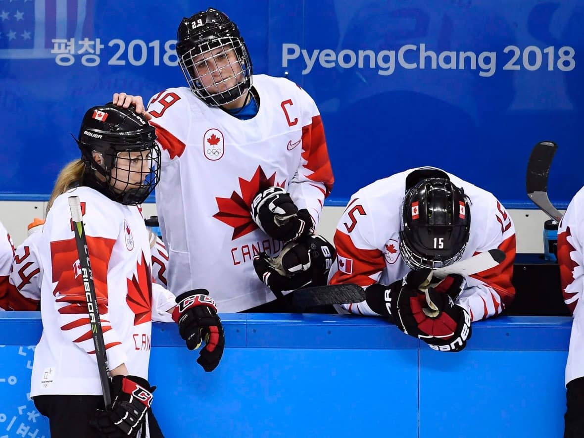 Marie-Philip Poulin, centre, comforts teammates after their shootout loss to the U.S. at the 2018 Olympics. The Team Canada captain has waited four years to avenge that loss at the Beijing Winter Olympics in February.  (Nathan Denette/Canadian Press - image credit)