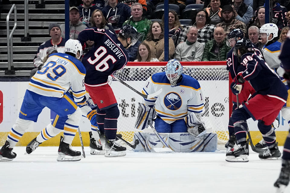 Buffalo Sabres goaltender Ukko-Pekka Luukkonen (1) blocks a shot in front of Columbus Blue Jackets center Jack Roslovic (96) and Sabres' Alex Tuch (89) during the first period of an NHL hockey game Friday, Feb. 23, 2024, in Columbus, Ohio. (AP Photo/Sue Ogrocki)