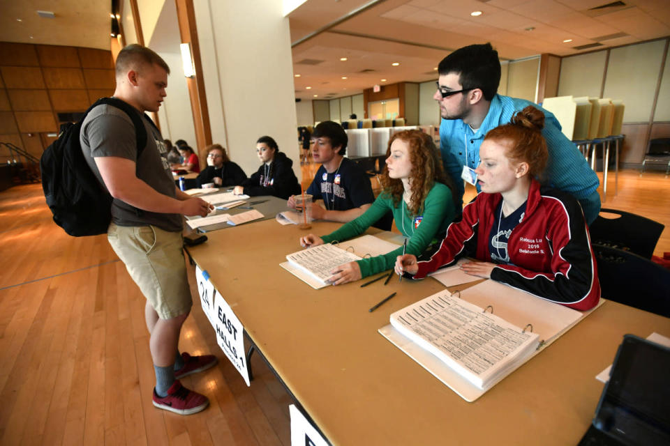 <p><b>Penn State student checks in to vote</b></p><p>Bellefonte Area High School students Annie Lucas, center, Becky Lucas, right, and Cody Allison, top, check in Penn State student Jarrett Patterson to vote as the high school students work the polls in the HUB-Robeson Center on the Penn State University campus, in University Park, Pa., Tuesday, April 26, 2016, on primary election day. <i>(Photo: Nabil K. Mark/Centre Daily Times via AP)</i></p>