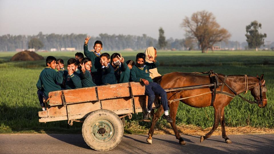 Students travel towards their school on a horse-cart, after schools re-opened since its closure on March 2020 due to the coronavirus pandemic, on the outskirts of Jammu, Wednesday, March 3, 2021.