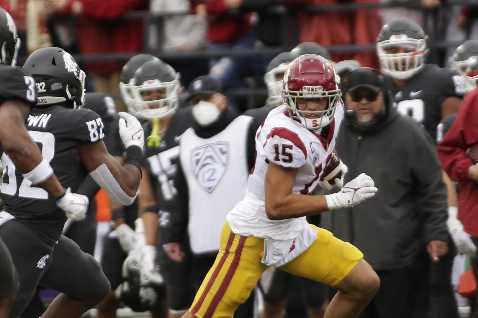 USC wide receiver Drake London runs with the ball in front of Washington State linebacker Travion Brown.