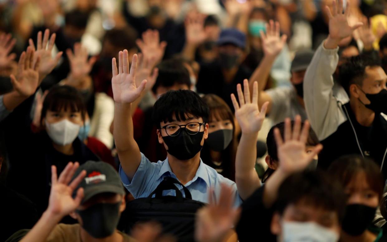 Protesters hold up their hands during an anti-government sit-in in a Hong Kong mall - REUTERS