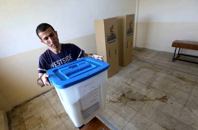 An electoral commission employee prepares a ballot box at a voting station in Arbil ahead of Monday's planned independence referendum for Iraq's Kurdistan region