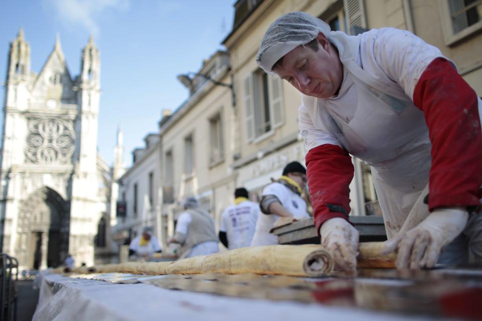 Volunteers assemble yule log coils in Vernon, France, while attempting to set a new Guinness World Record for the longest yule log.