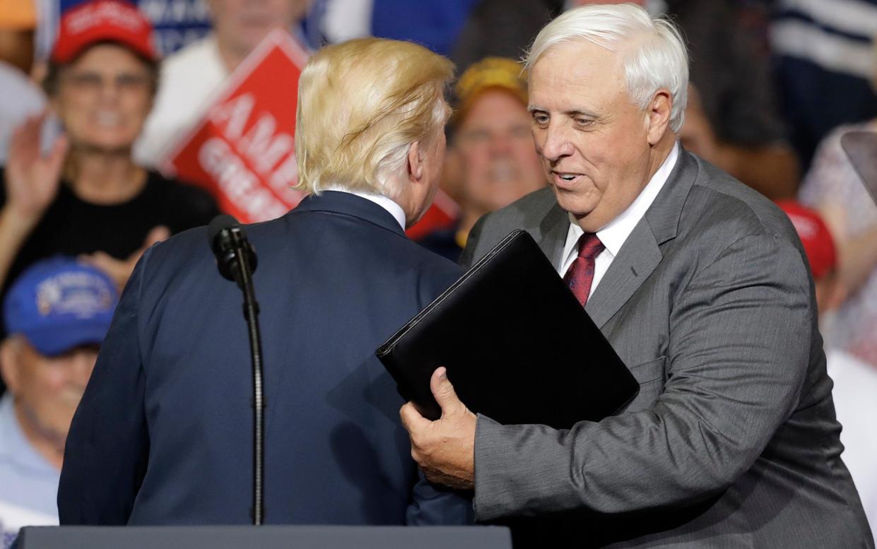 President Donald Trump talks with West Virginia Gov. Jim Justice before Justice spoke during a rally Thursday, Aug. 3, 2017, in Huntington, W.Va - AP